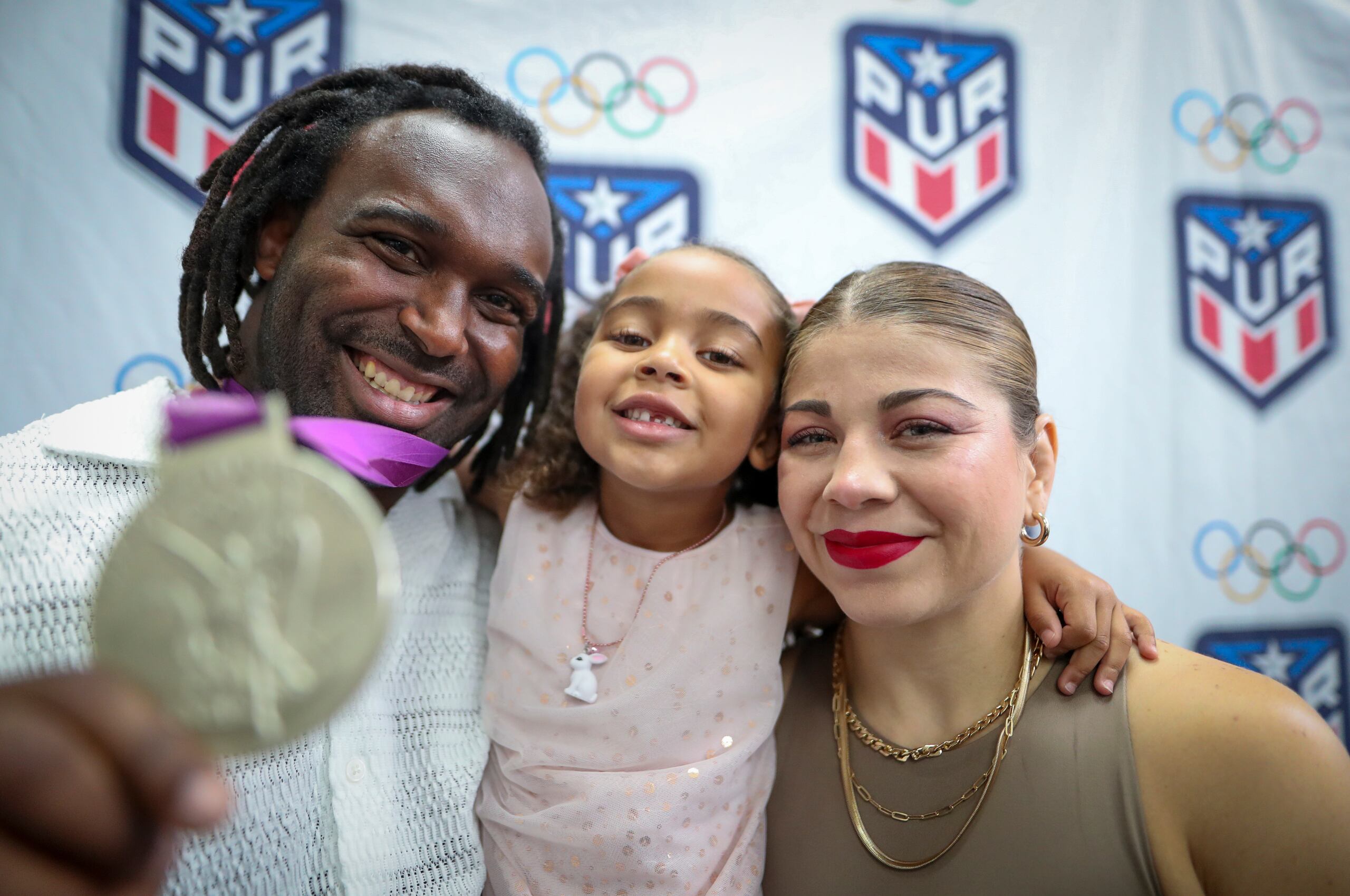 Jaime Espinal nuestra la medalla de plata que ganó en Londres 2012. Le acompañan su hija Joy y su esposa Jane Valencia.