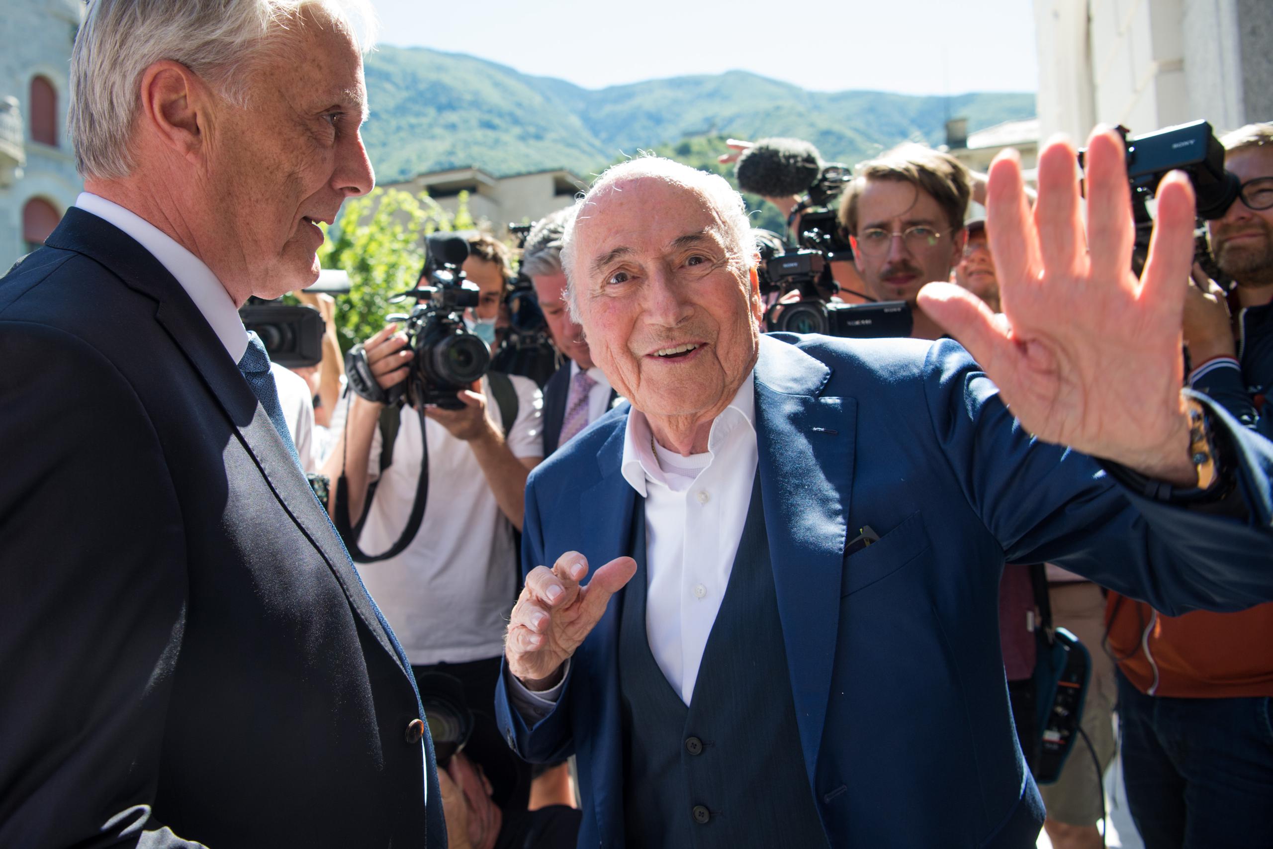 El expresidente de la FIFA, Sepp Blatter, saluda a los periodistas a su salida del tribunal suizo en el cual fue absuelto de cargos de fraude junto al expresidente de la UEFA, Michel Platini.