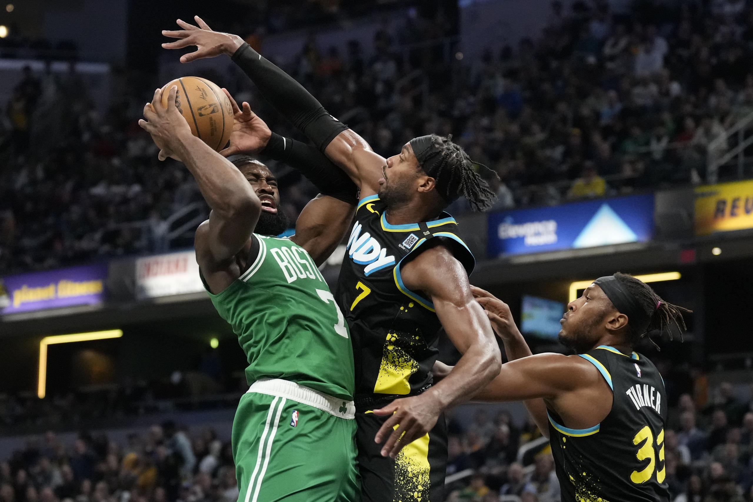 Jaylen Brown, escolta de los Celtics de Boston, ataca el canasto frente a Buddy Hield, alero de los Pacers de Indiana.