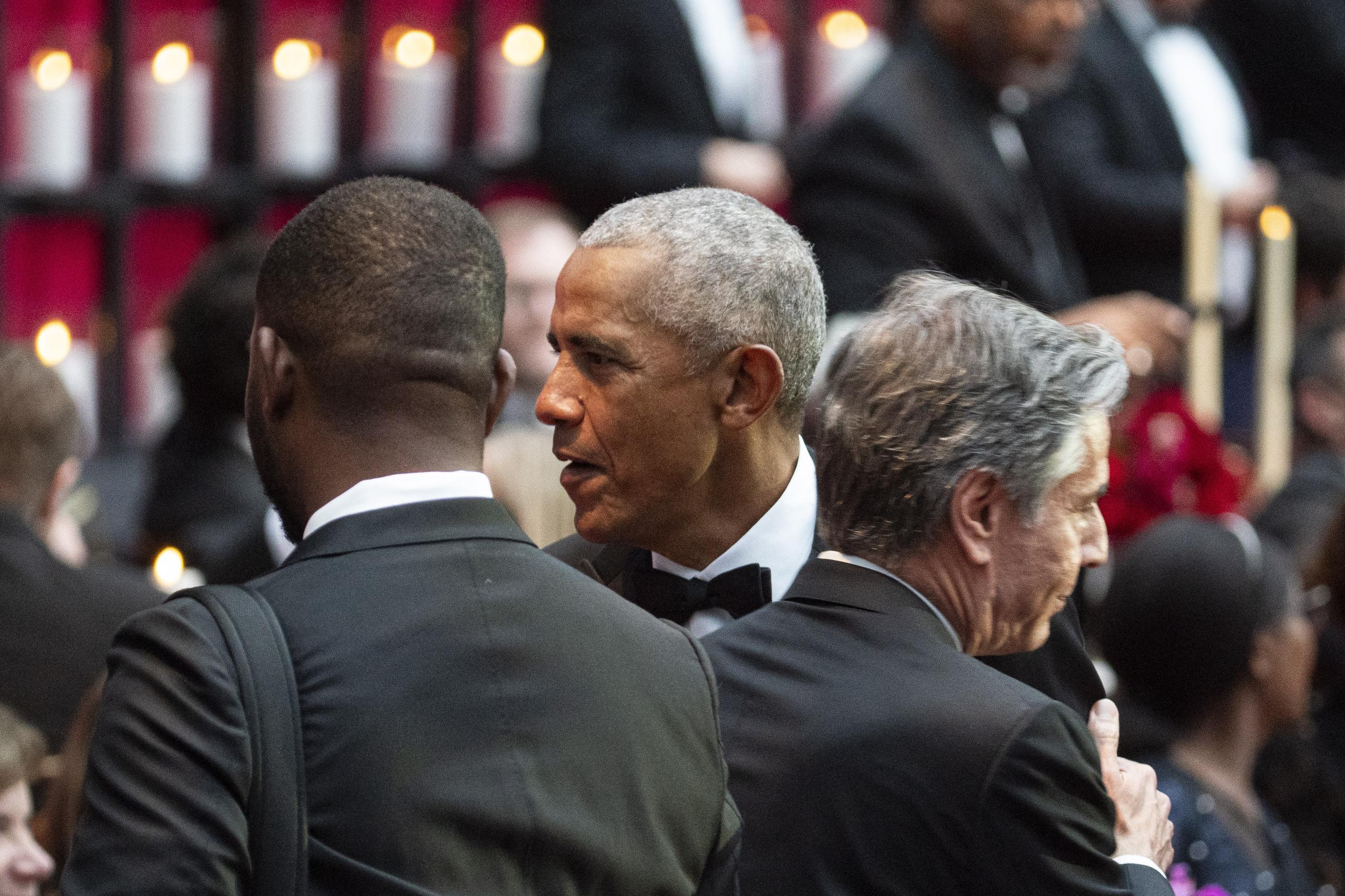 El expresidente estadounidense Barack Obama, al centro, saluda al secretario de Estado de Estados Unidos, Antony Blinken, a la derecha, durante la cena de ayer.