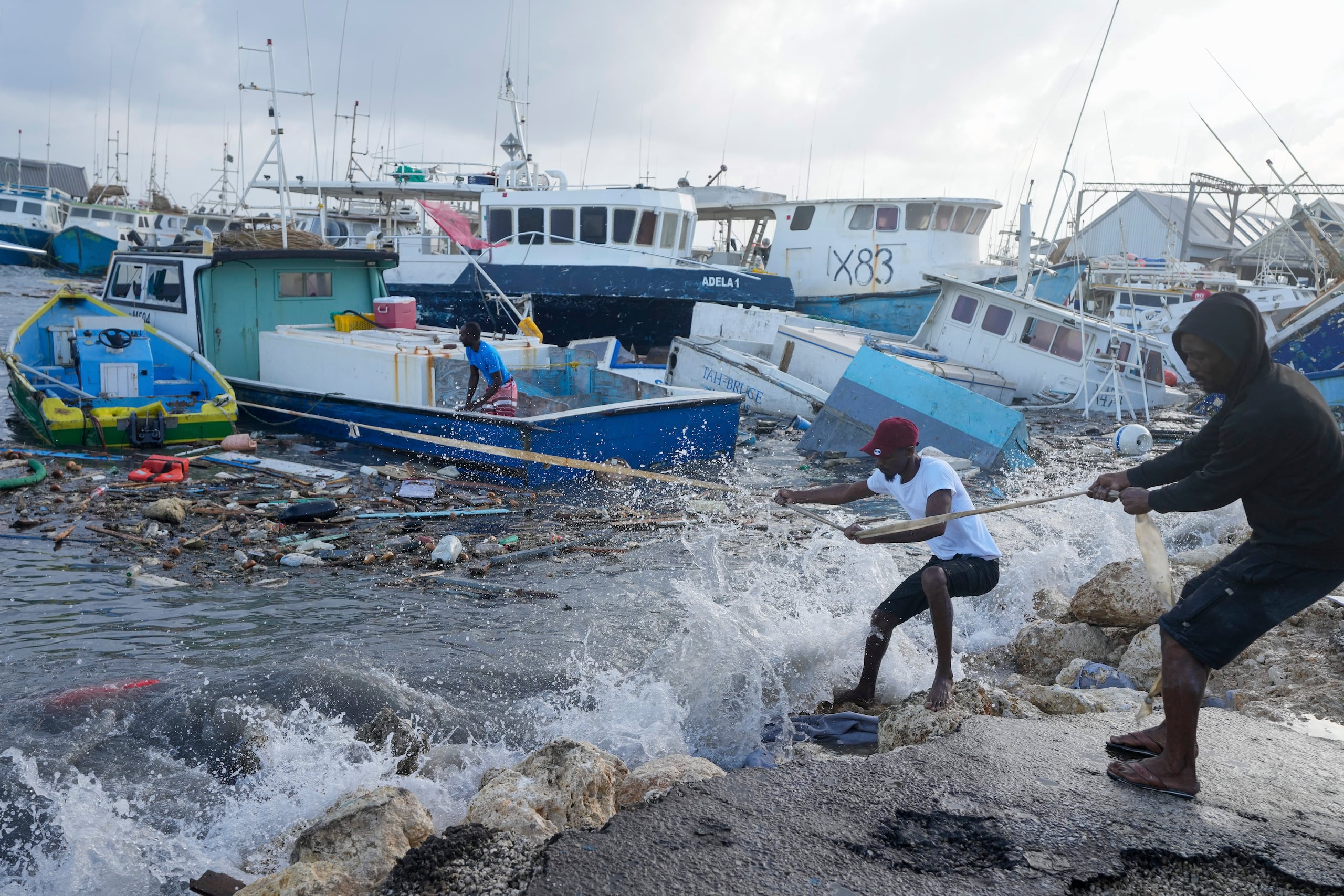 Pescadores tiran de un barco dañado por el huracán Beryl de regreso al muelle en Bridgetown Fisheries en Barbados, el lunes 1 de julio de 2024. (Foto AP/Ricardo Mazalan)