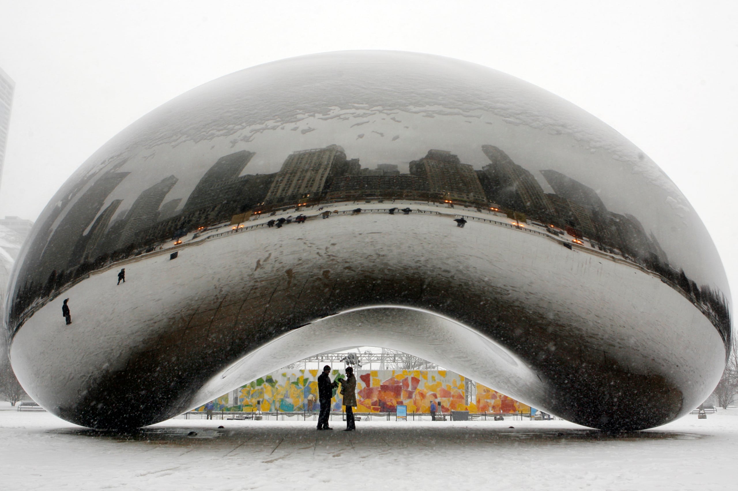 En esta foto de archivo del 31 de enero de 2008, se ve a una pareja en la parte inferior de la escultura de acero inoxidable de 110 toneladas de Anish Kapoor llamada "Cloud Gate" y apodada "The Bean" en Millennium Park en Chicago. (AP Foto/Nam Y. Huh, Archivo)