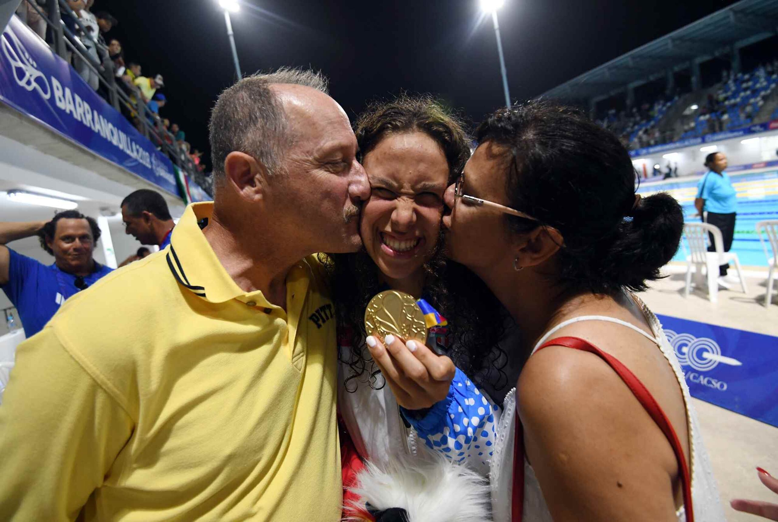 Kristen Romano ganó el lunes una medalla de oro en el evento de los 400 metros combinados individual. En la foto, la joven es besada por sus padre Mike y  su madre Brenda.