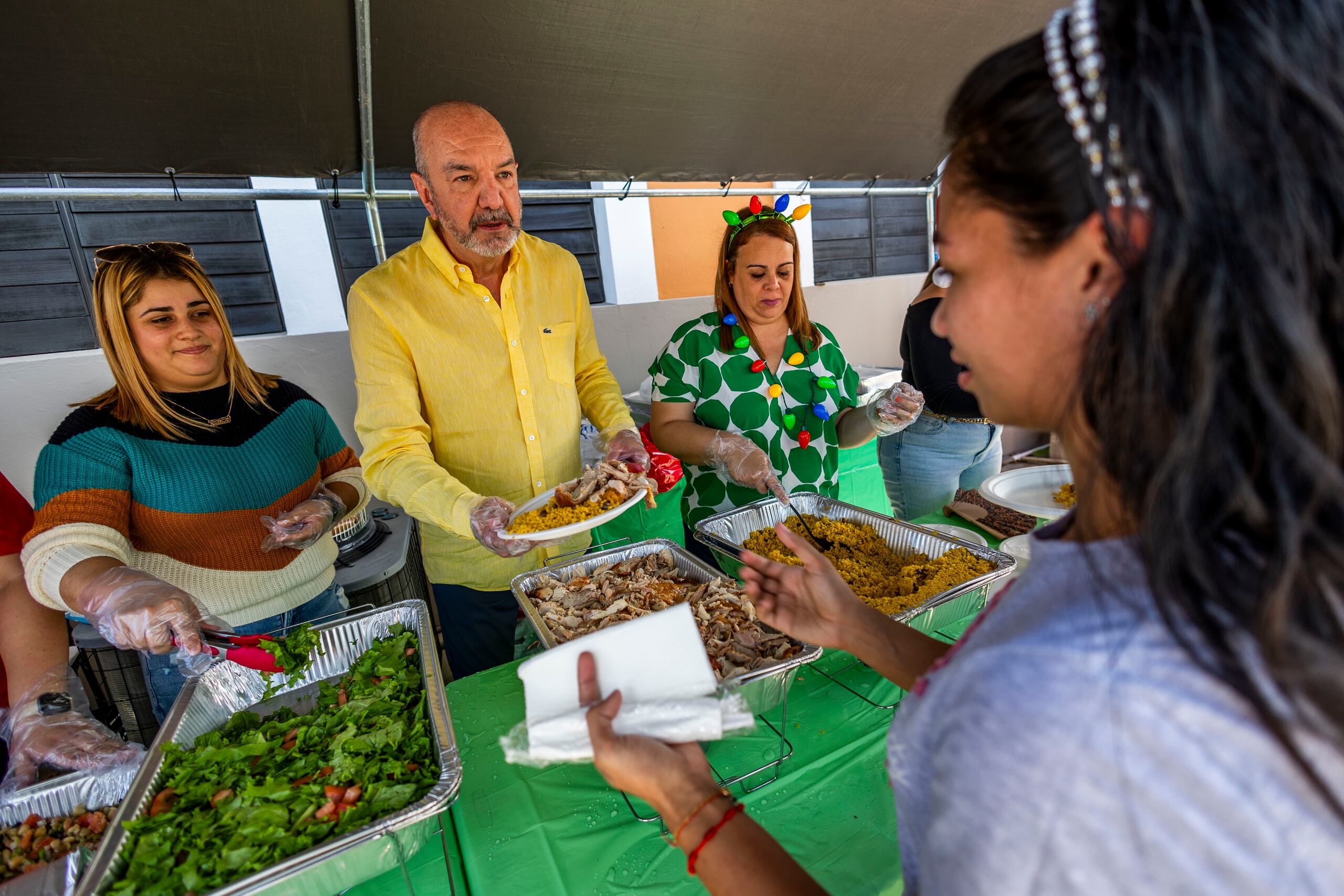 Como parte del evento, se declaró el inicio de la Navidad en el recinto. Aquí, el rector Luis A Tapia Maldonado sirve comida junto a otras empleadas de la institución como parte del almuerzo navideño.