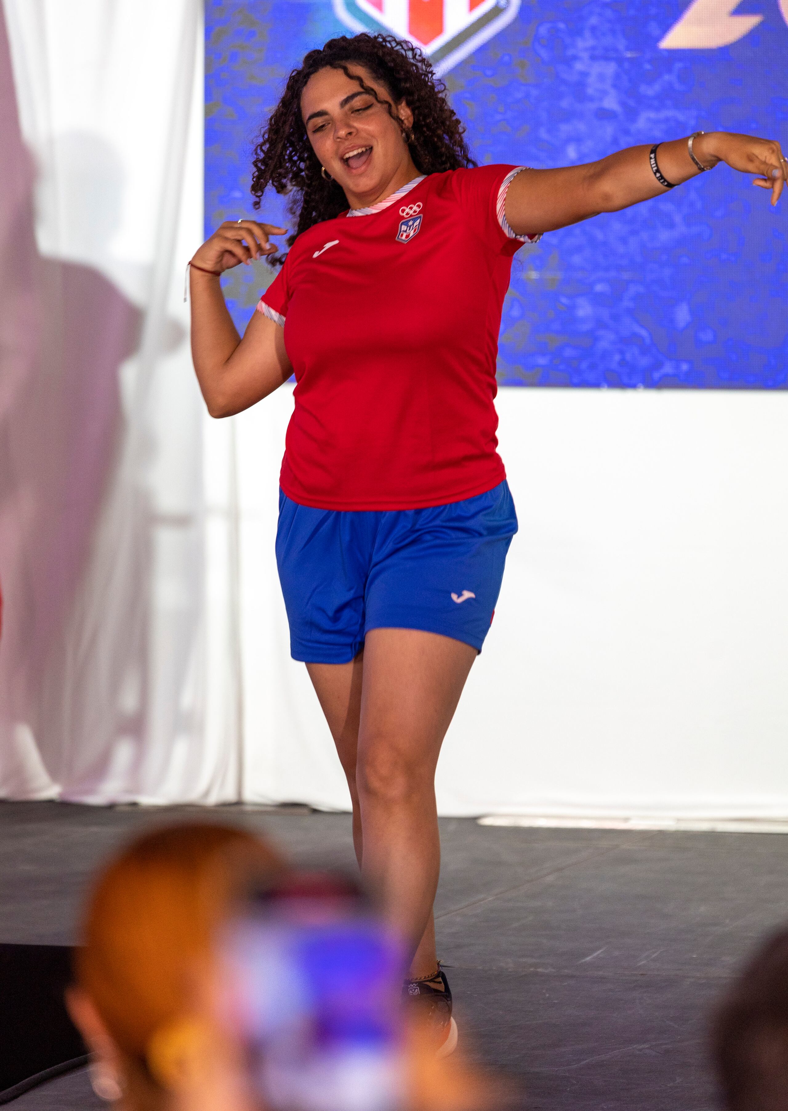 La arquera Alondra Rivera hace el gesto de su deporte durante el desfile de la vestimenta casual que llevará la delegación de Puerto Rico en París 2024.