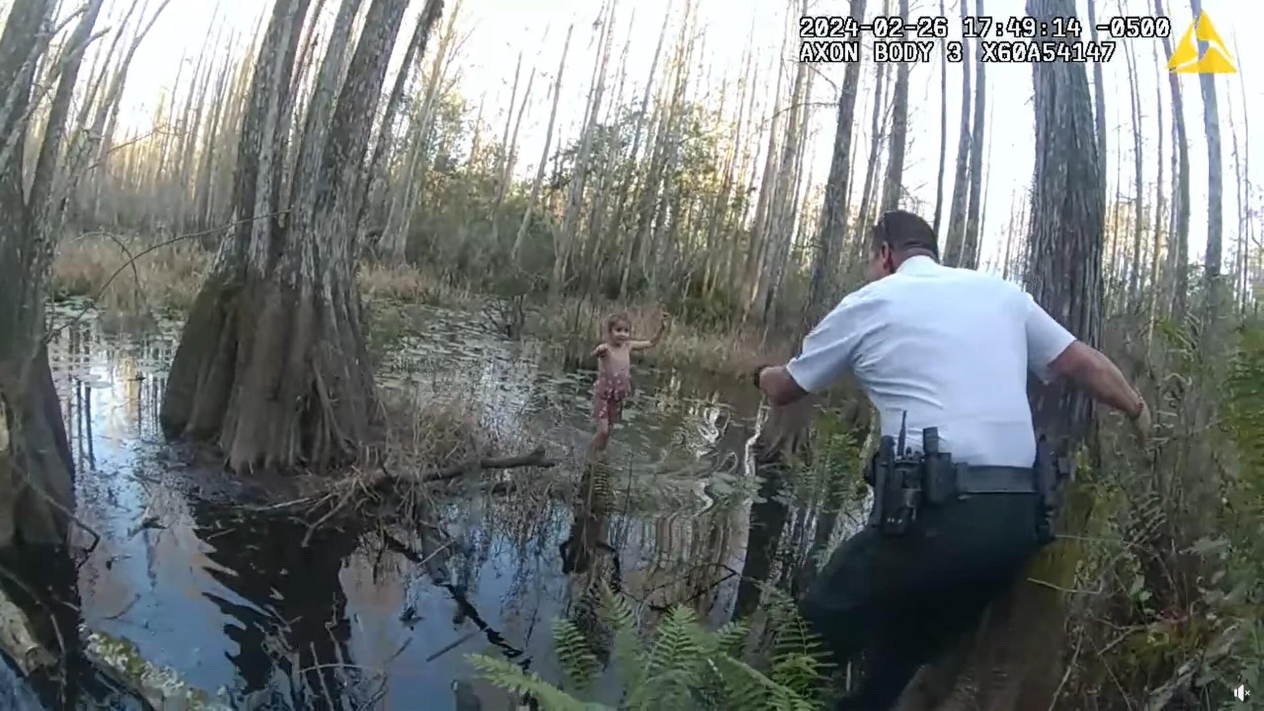 Captura de un vídeo divulgado por la Oficina del Alguacil del Condado Hillsborough donde se muestra a uno de sus agentes llamando a la niña al ser hallada con el agua hasta los tobillos en un pantano cerca de Tampa, Florida.